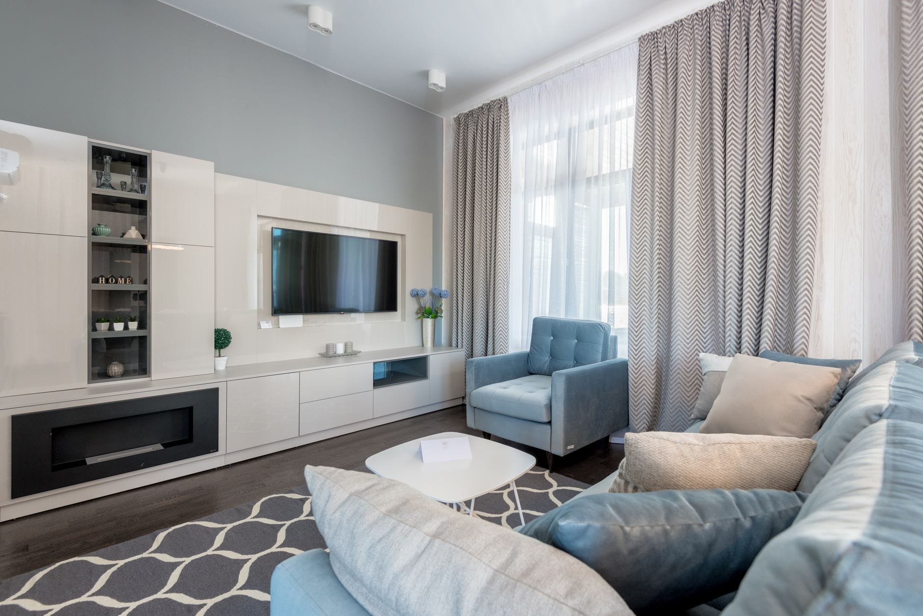 Nowoczesny salon z beżową sofą, dywanem i eleganckimi dodatkami