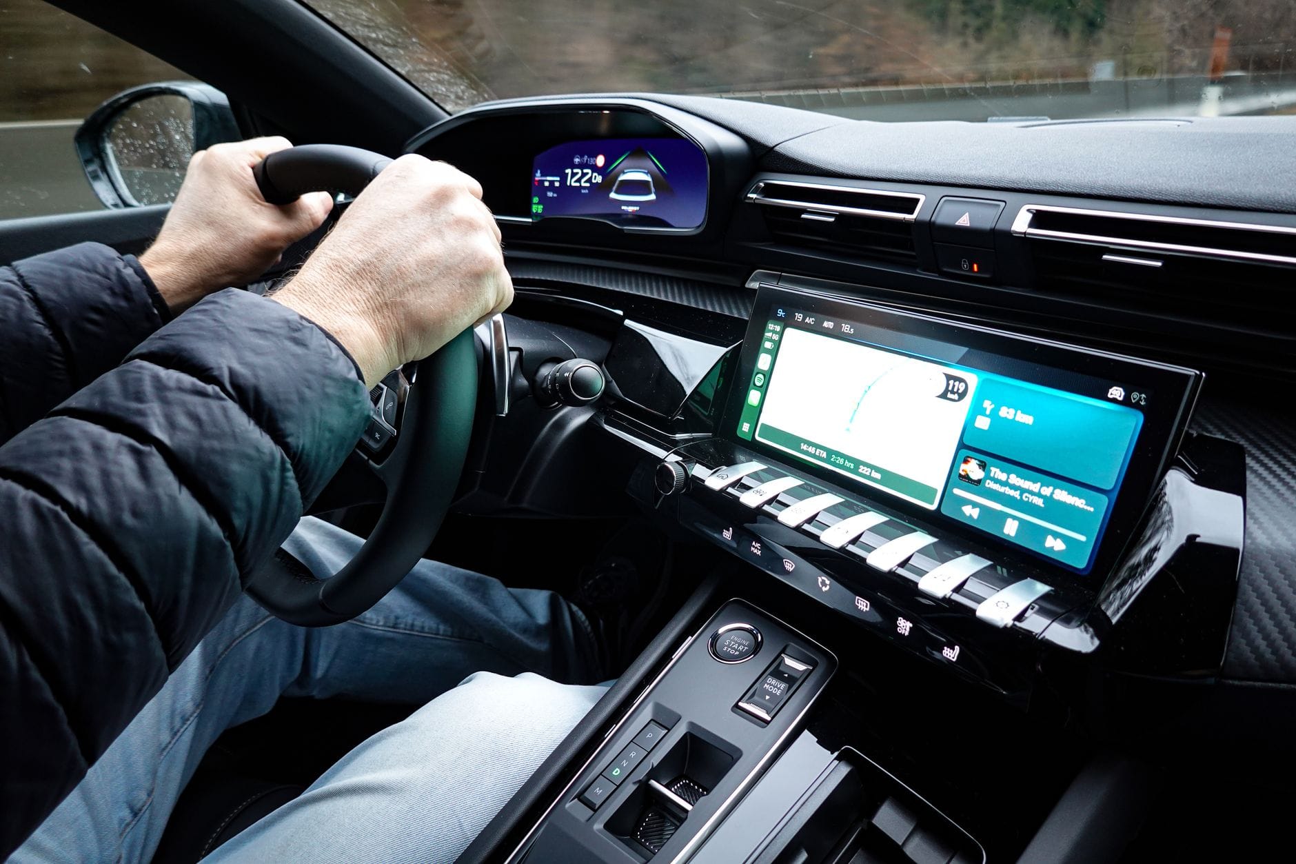 Wnętrze nowoczesnego auta elektrycznego z kierowcą trzymającym kierownicę